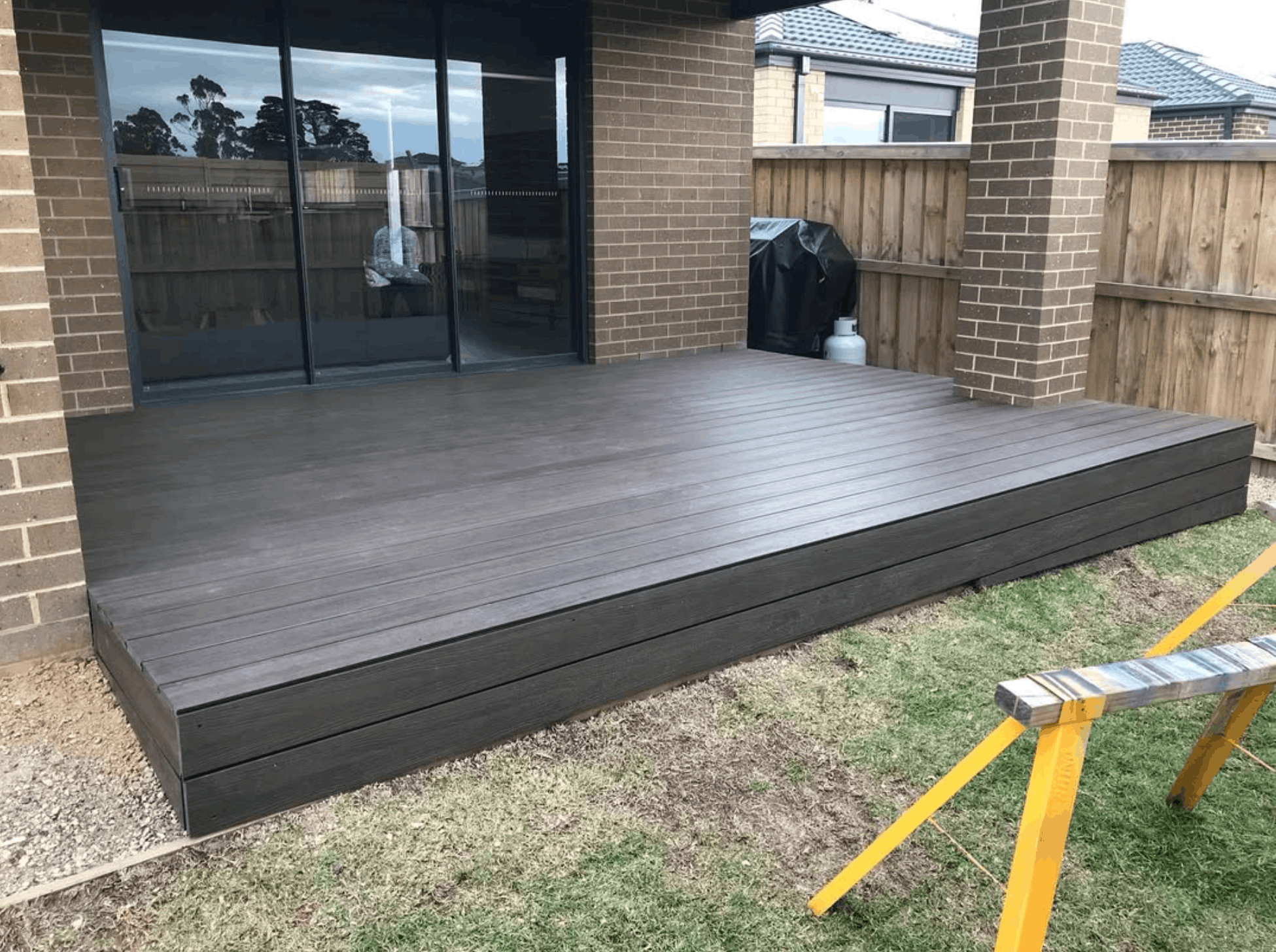 Composite timber deck with steps wrapping a backyard living area
