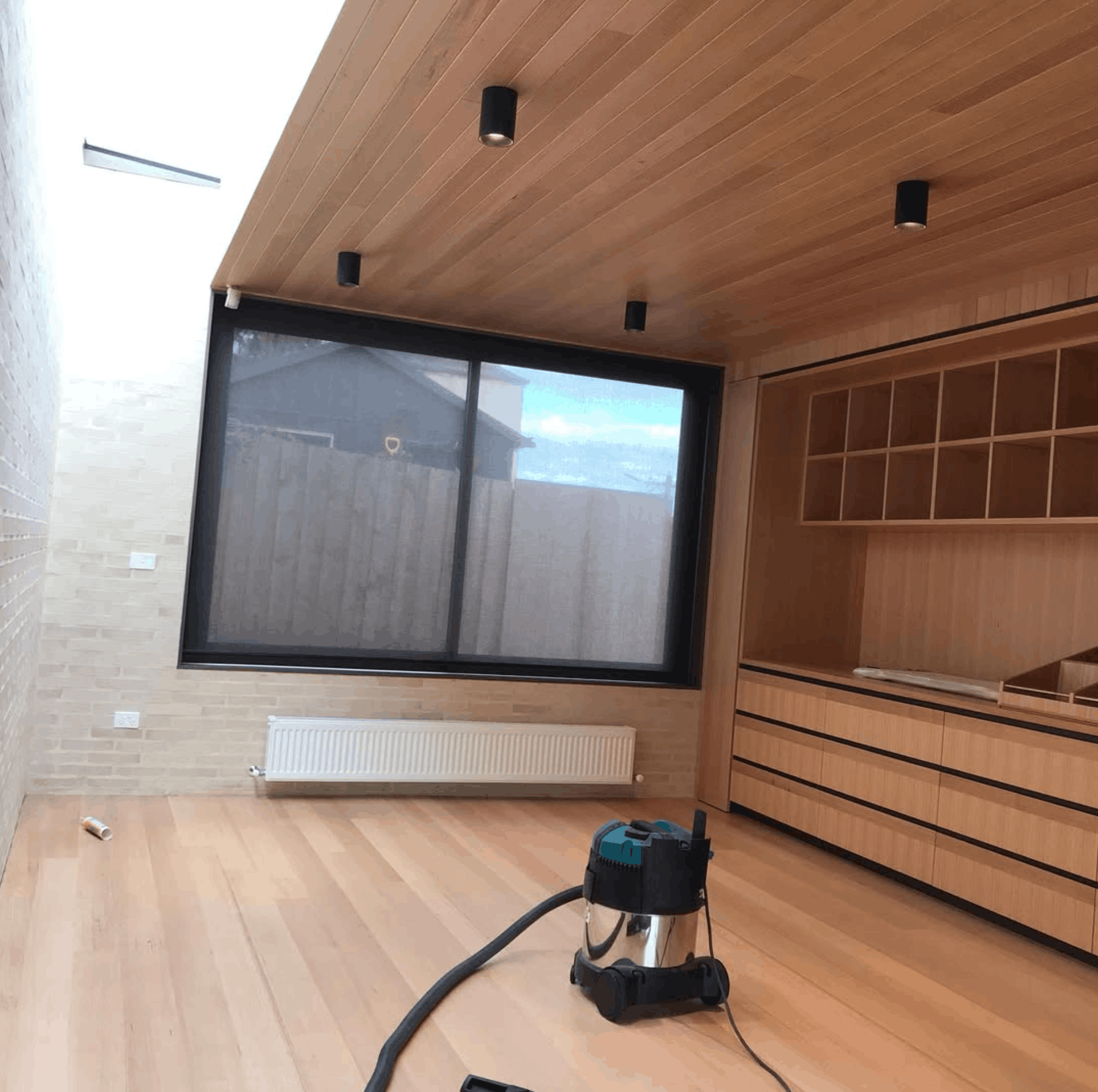 Timber-lined ceiling and built-in oak shelving in a renovated living room
